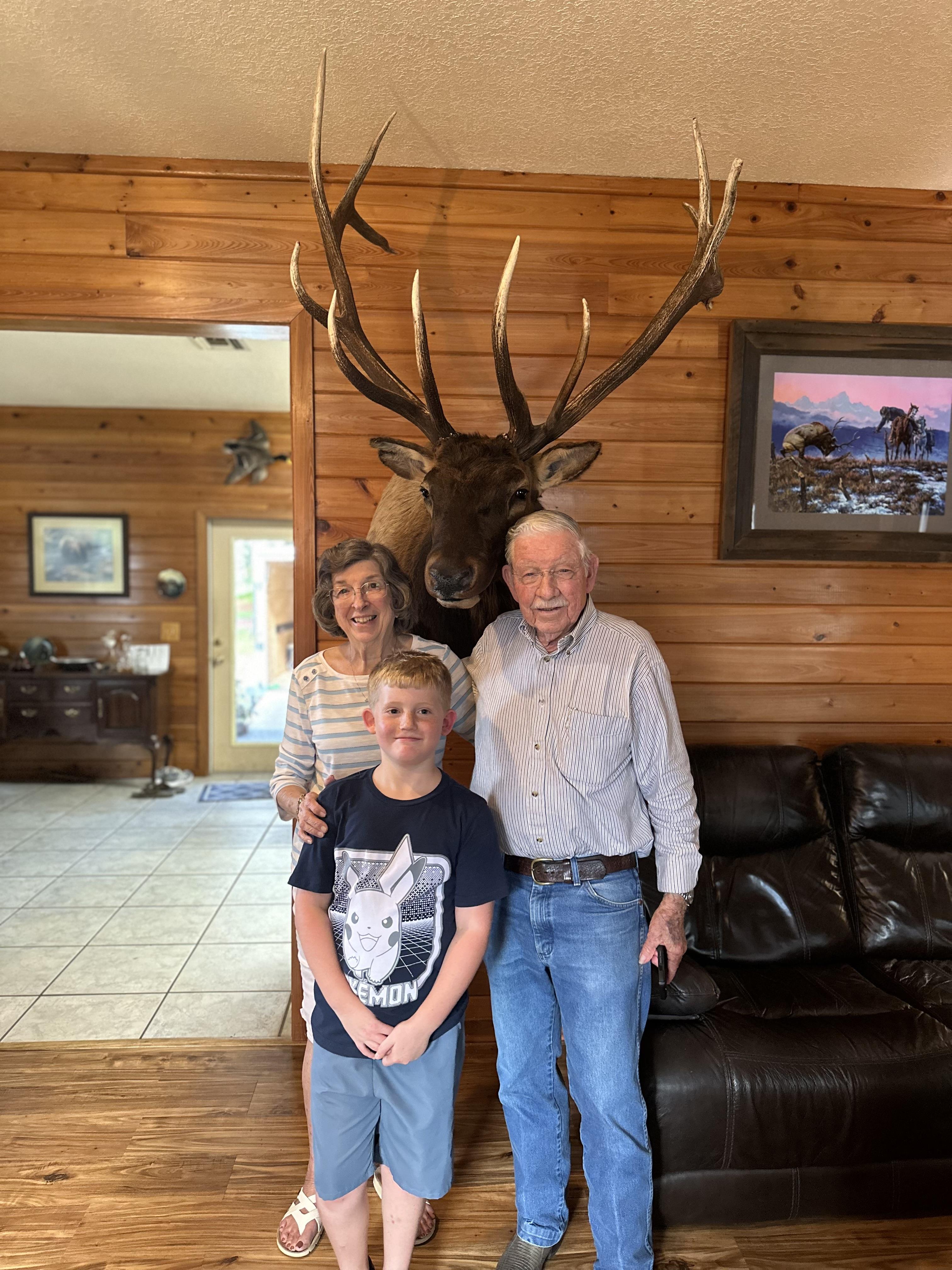 A family posing for a picture in a room with a moose head