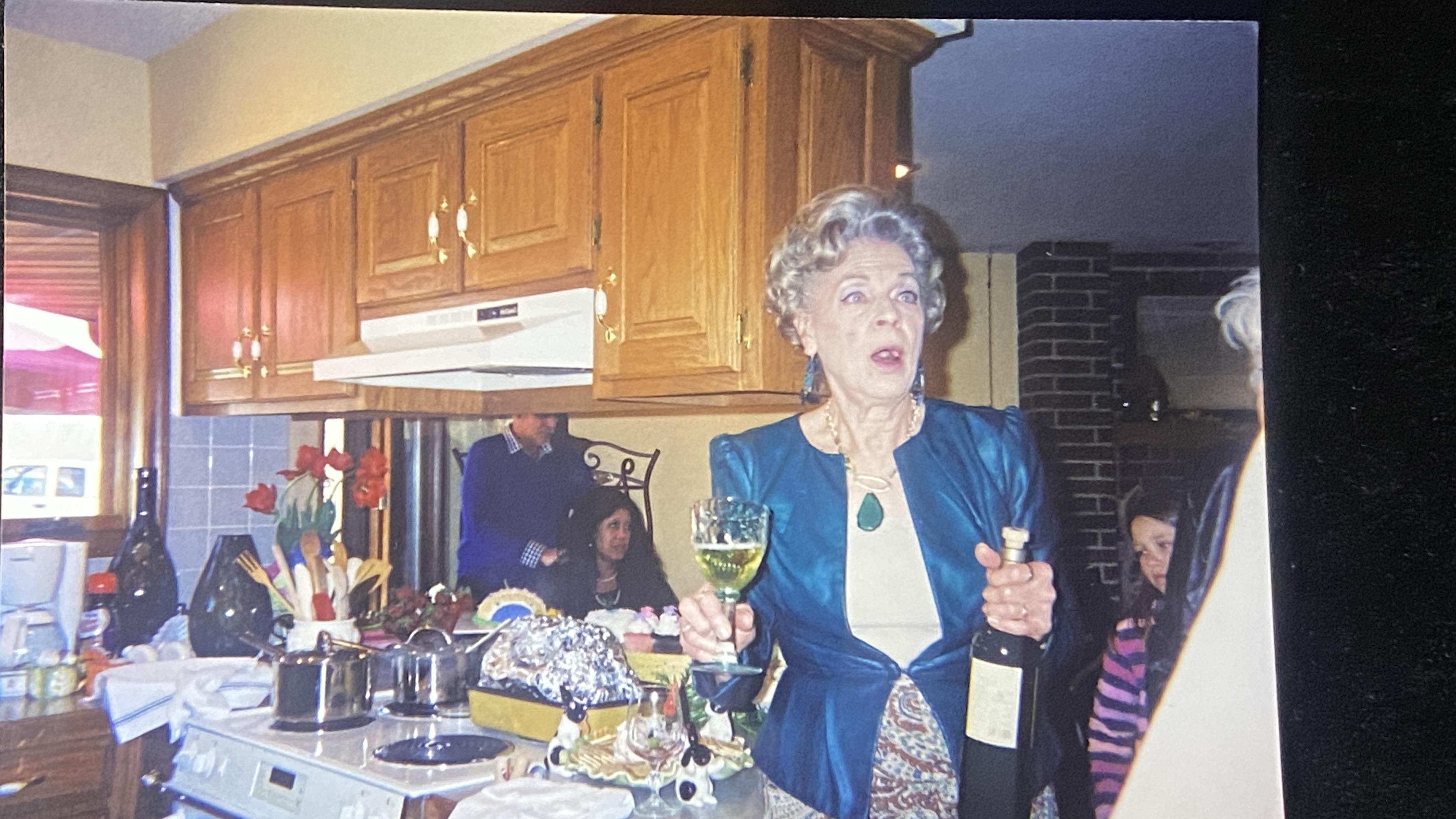 A woman holding a wine glass and a bottle