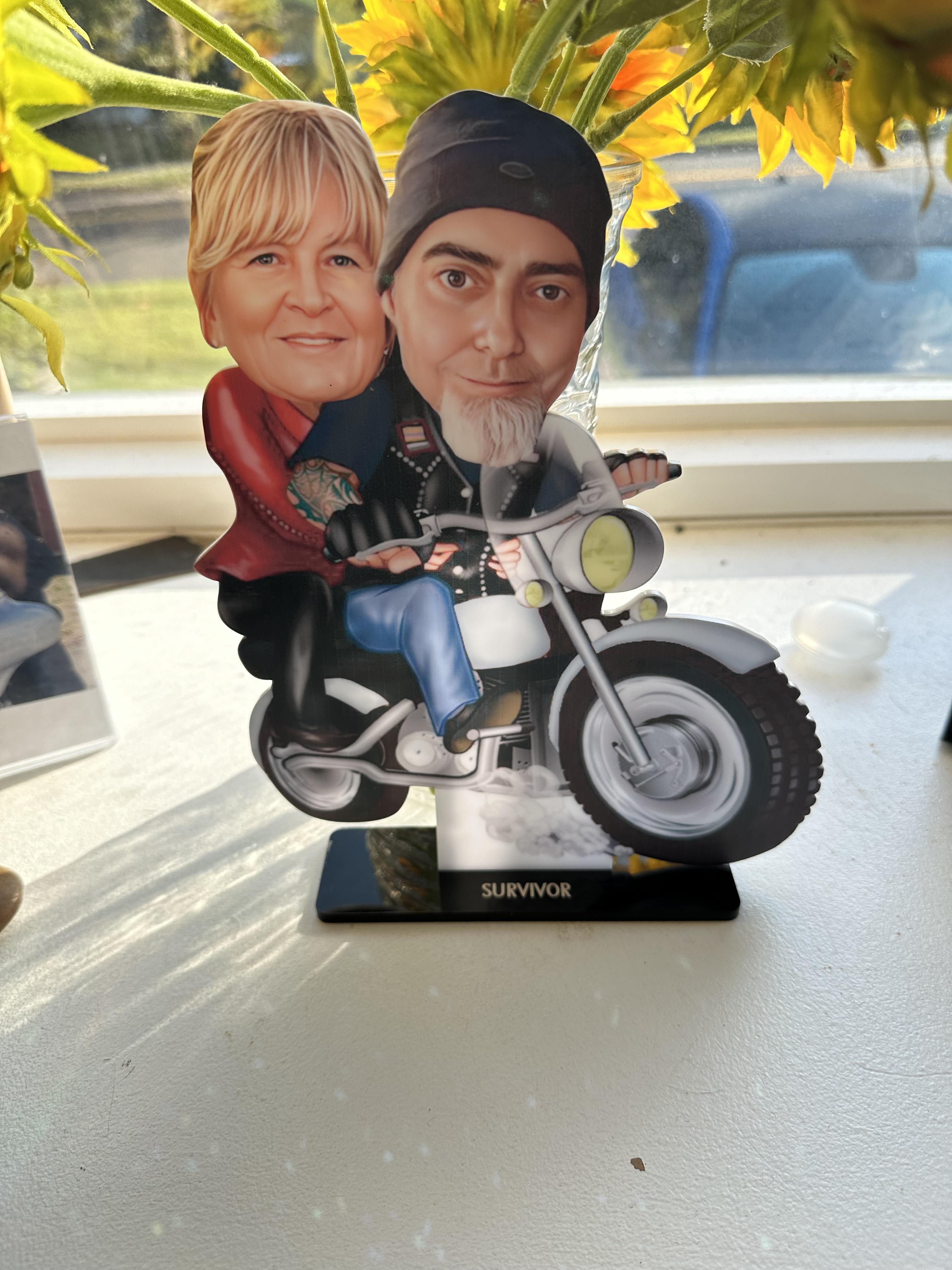 A cut out of a cardboard cutout of a man and a woman on a motorcycle