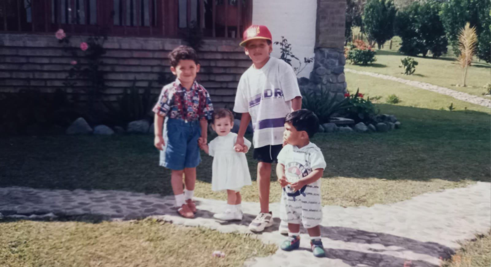 A group of children standing on a sidewalk