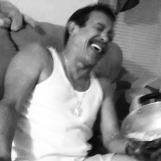 A man laughing while holding a pot