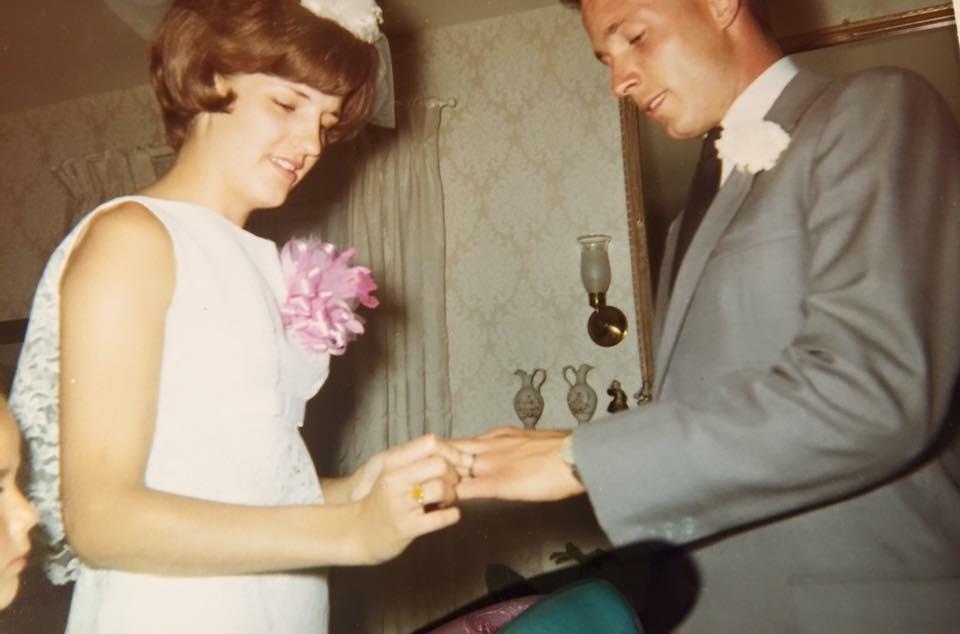 A man and woman wearing wedding rings