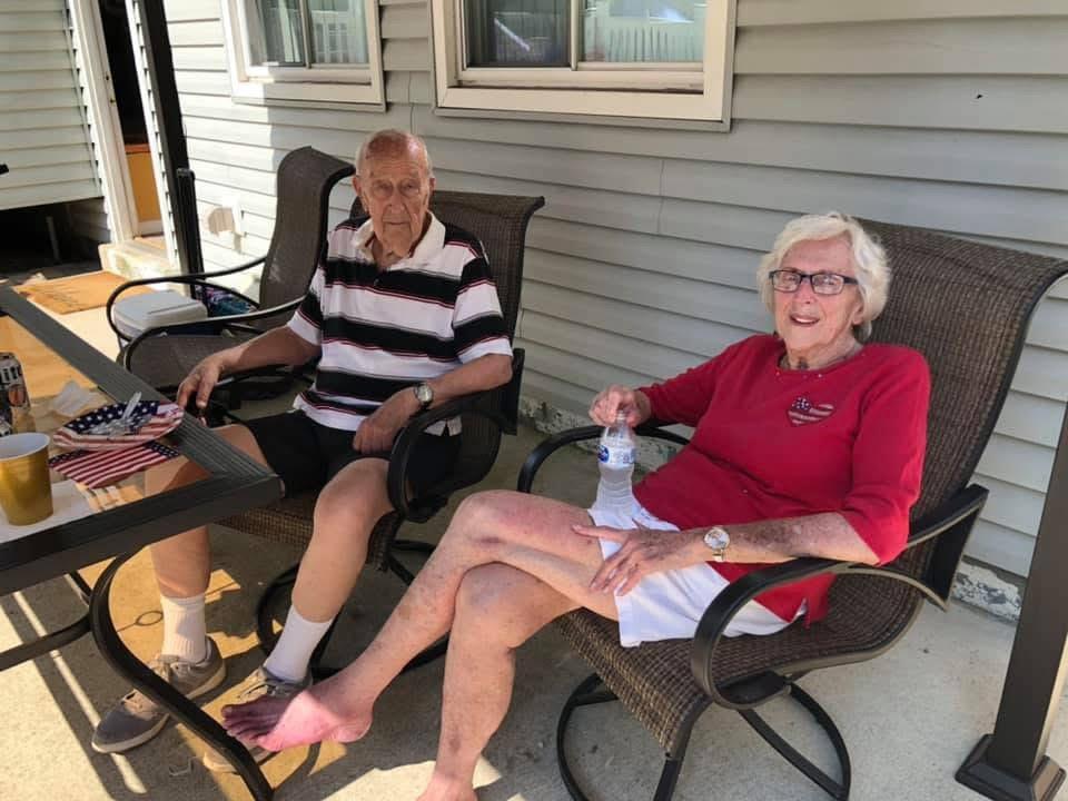A man and woman sitting on chairs outside