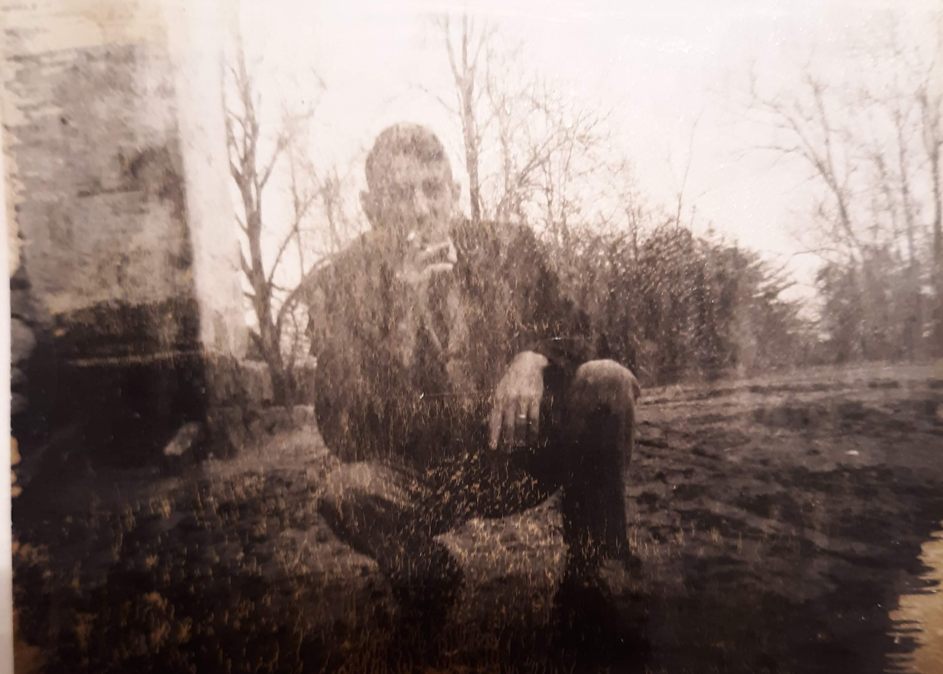 A man sitting in a dirt field