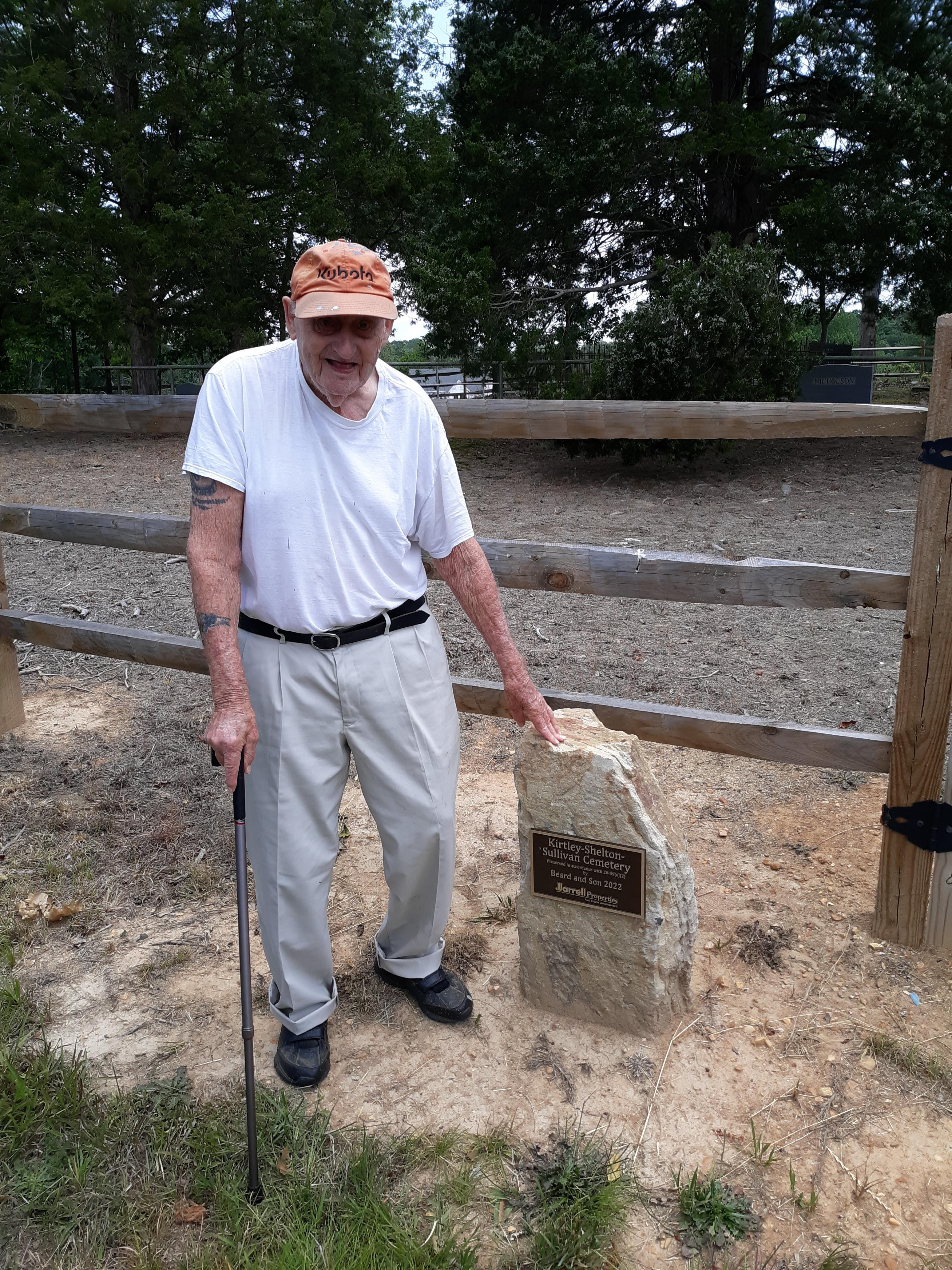 A man standing next to a rock