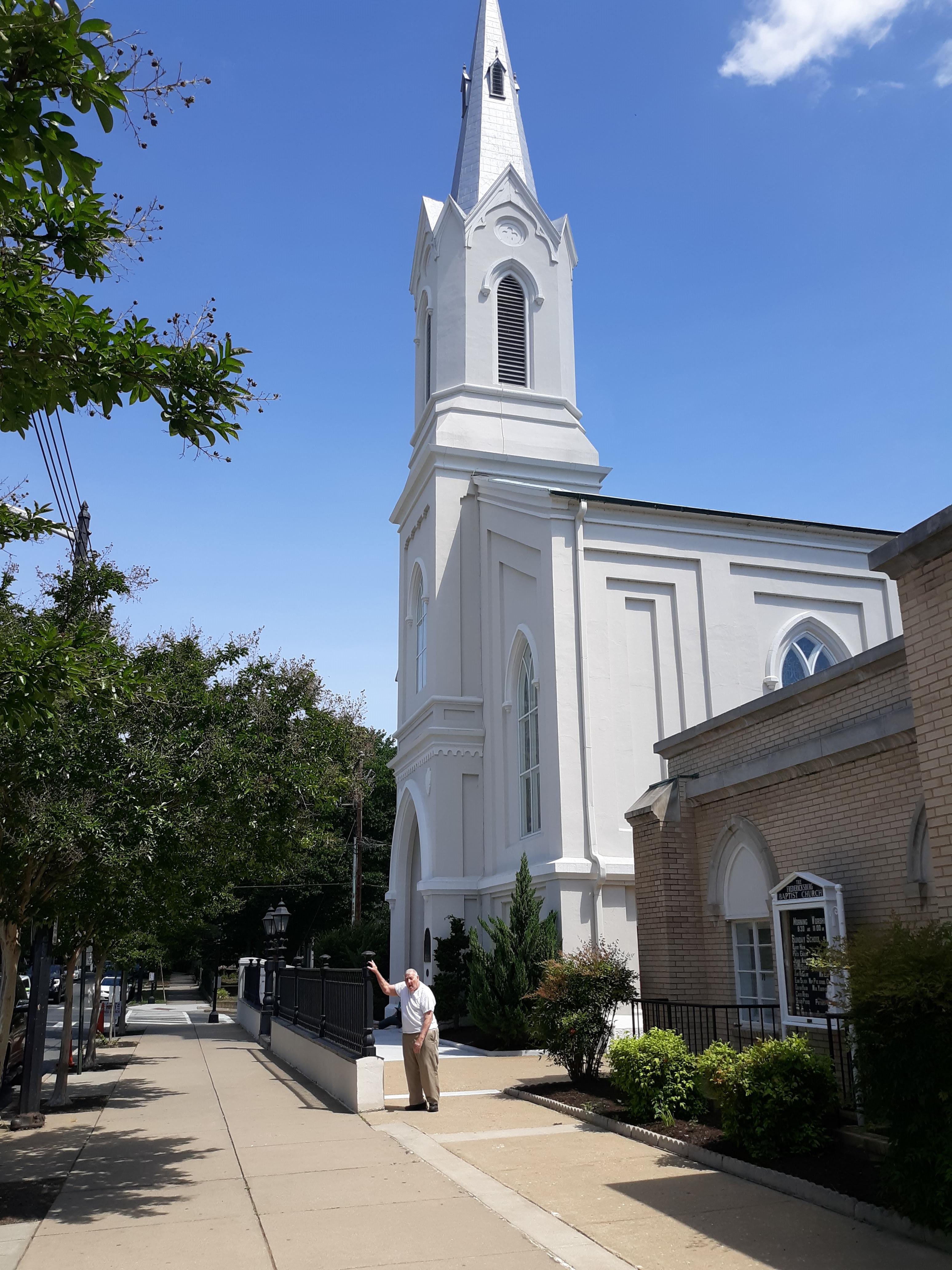 A man standing in front of a white building