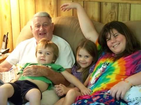 A man and woman sitting on a couch with children
