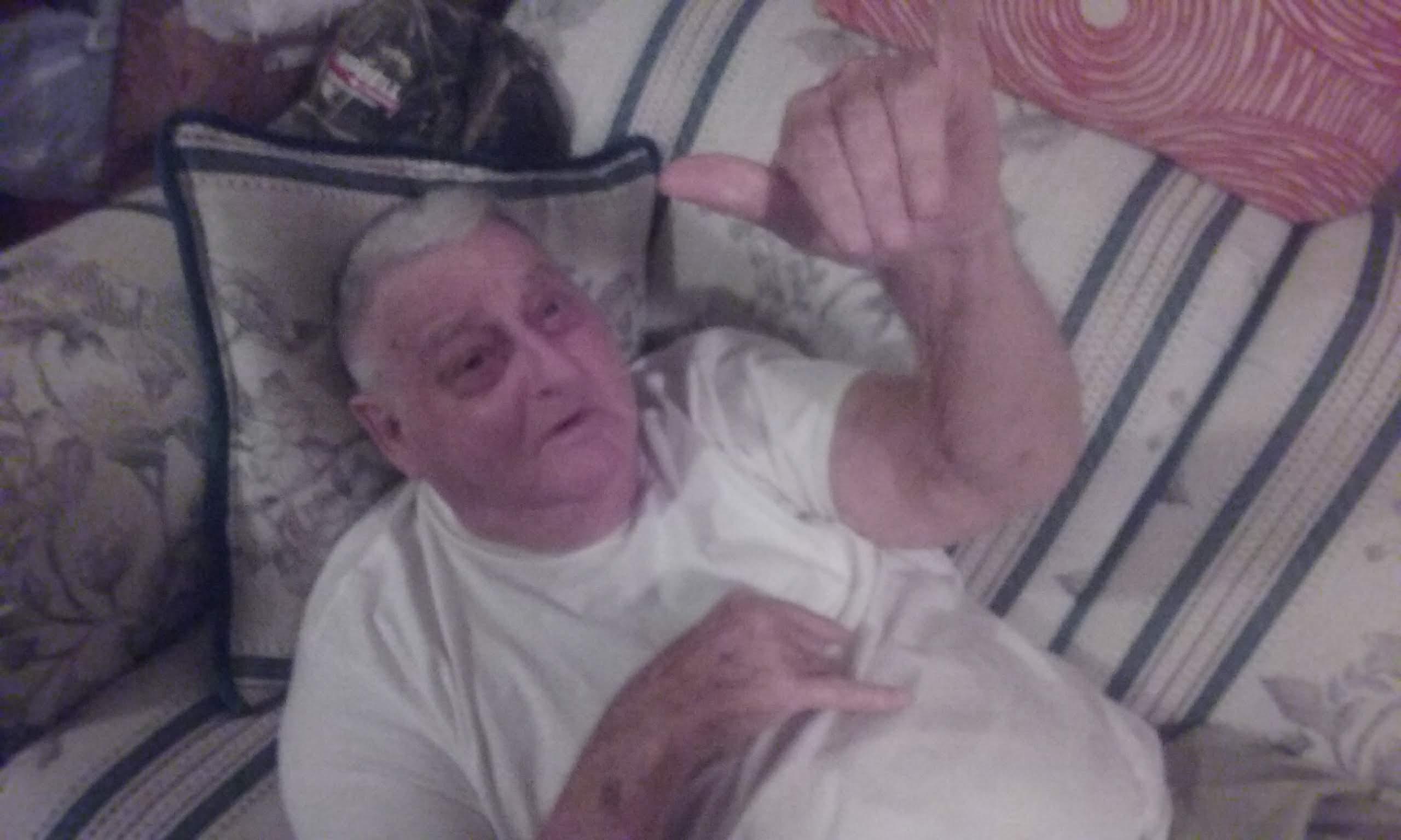 A man lying down with his hand up