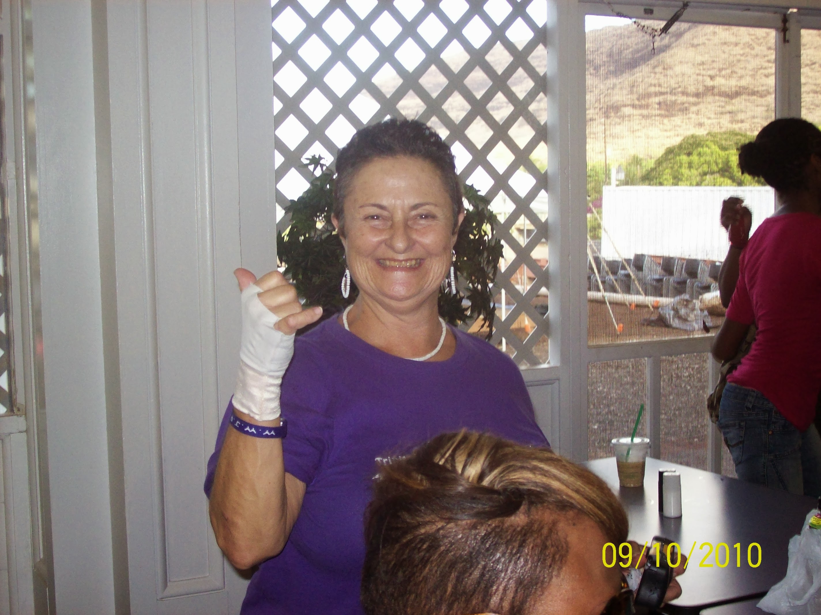 A woman in purple shirt giving a thumbs up