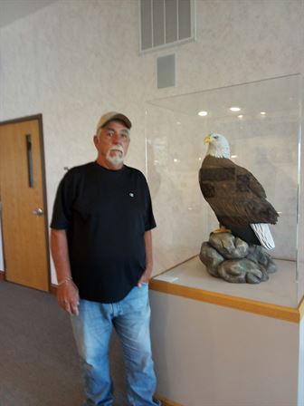 A man standing next to a statue of a bird