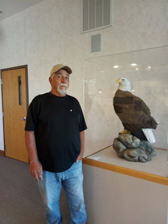 A man standing next to a statue of a bird