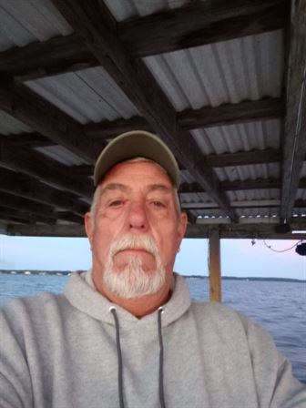 A man with a beard and hat under a roof
