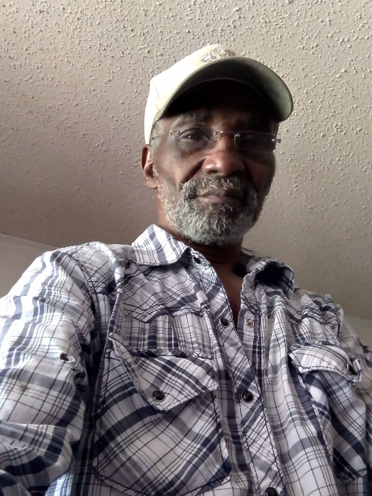 A man wearing a hat and a plaid shirt