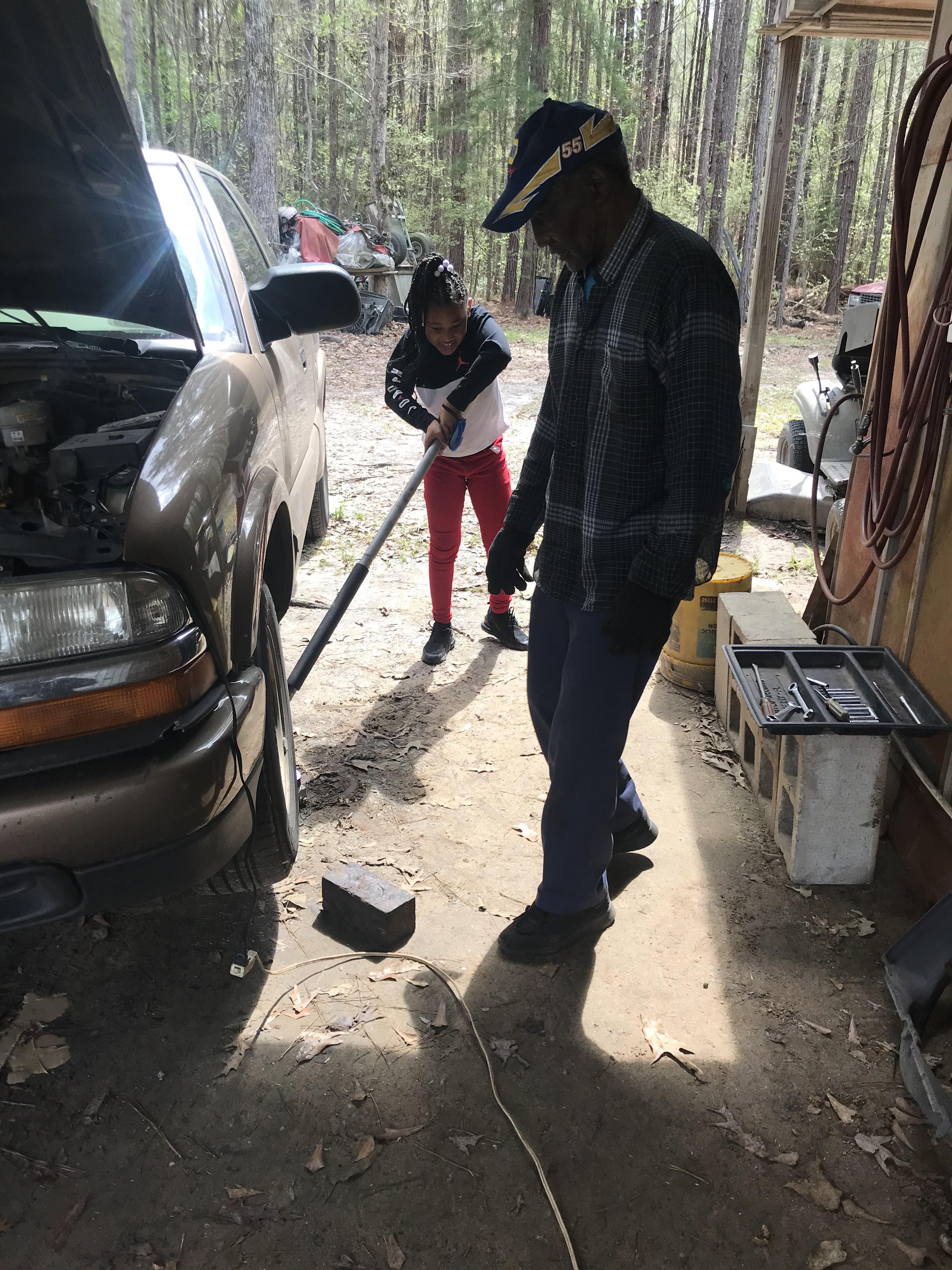 A man and woman holding a tool