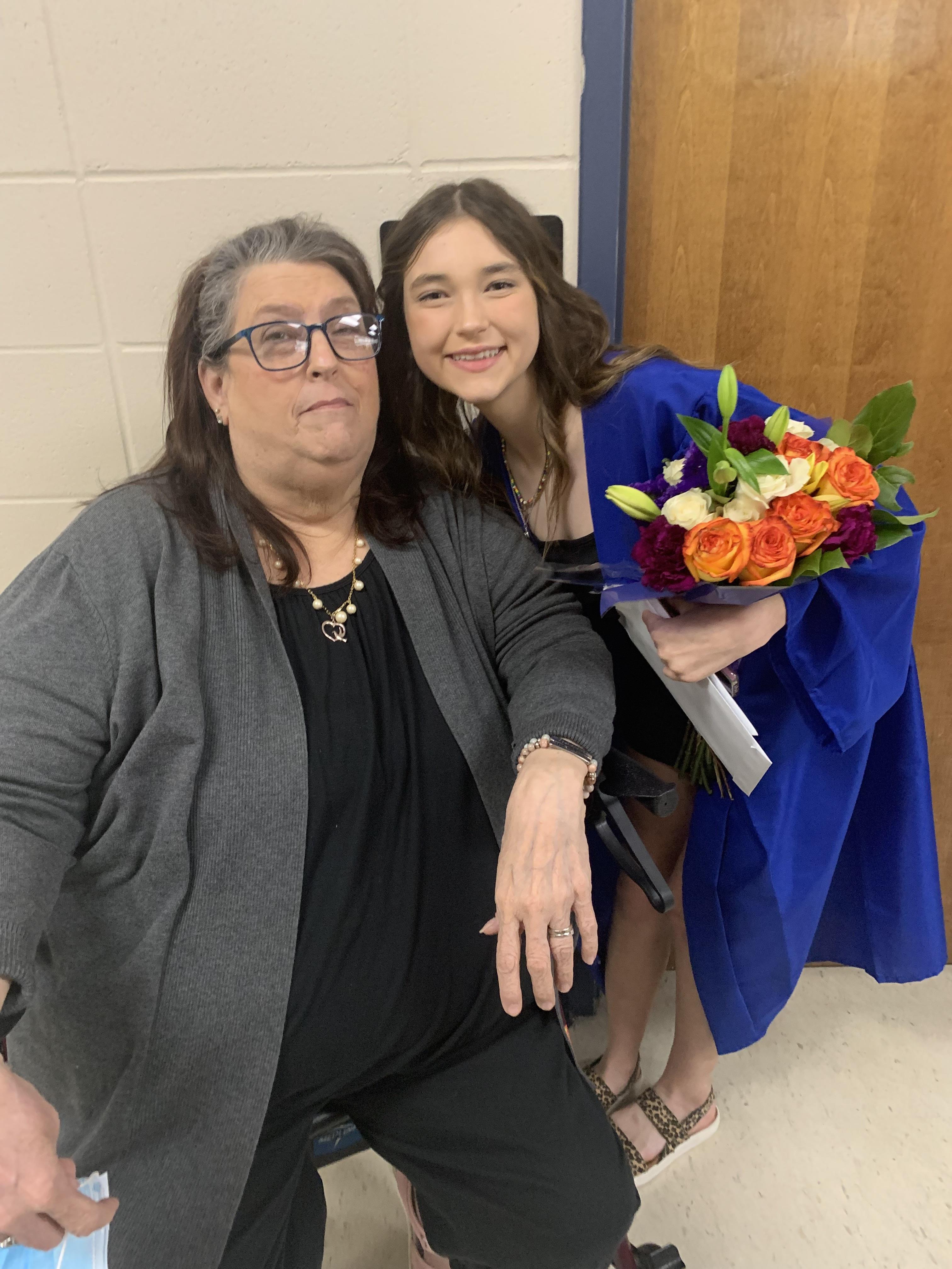 A woman holding a bouquet of flowers next to a woman