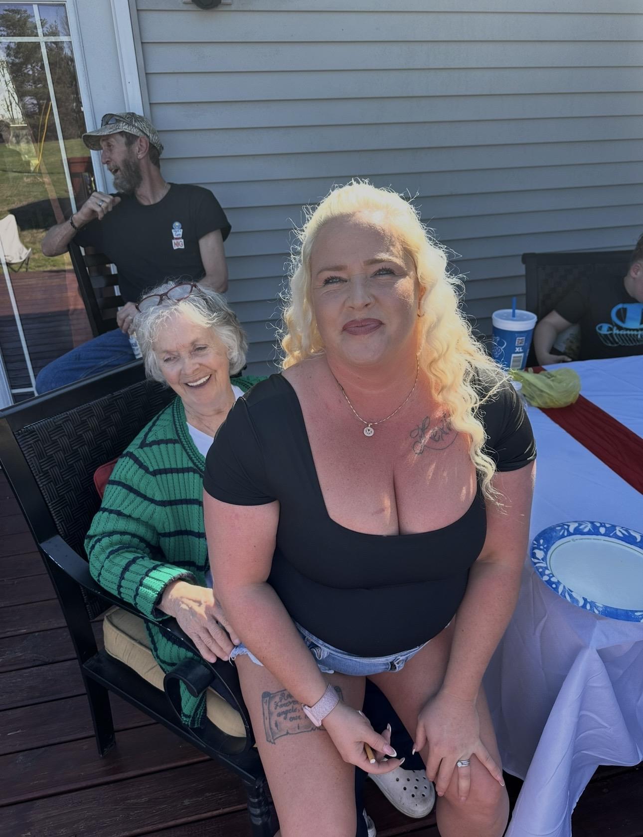 A woman sitting on a chair with a woman in the background
