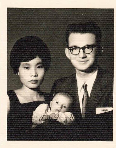 A man and woman holding a baby