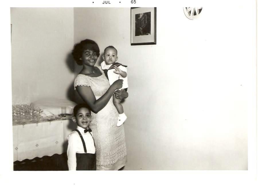 A woman holding a baby and a boy