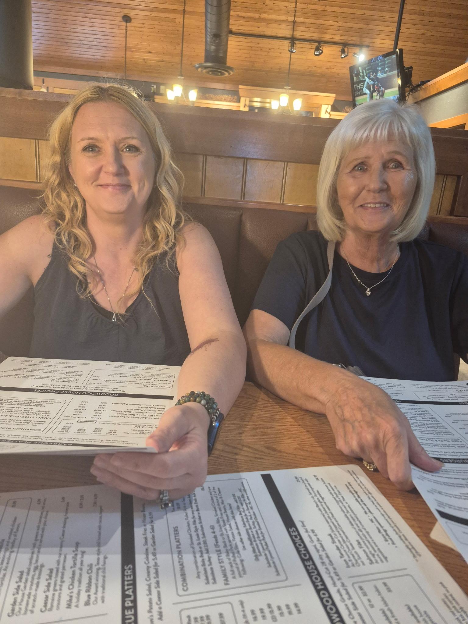 Two women sitting at a table with papers