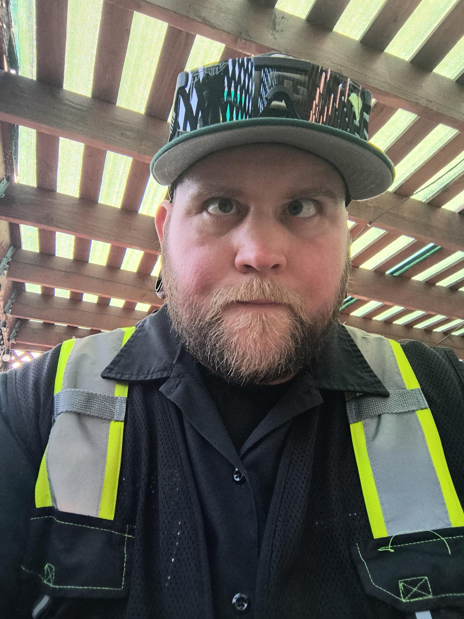 A man wearing a hat and vest
