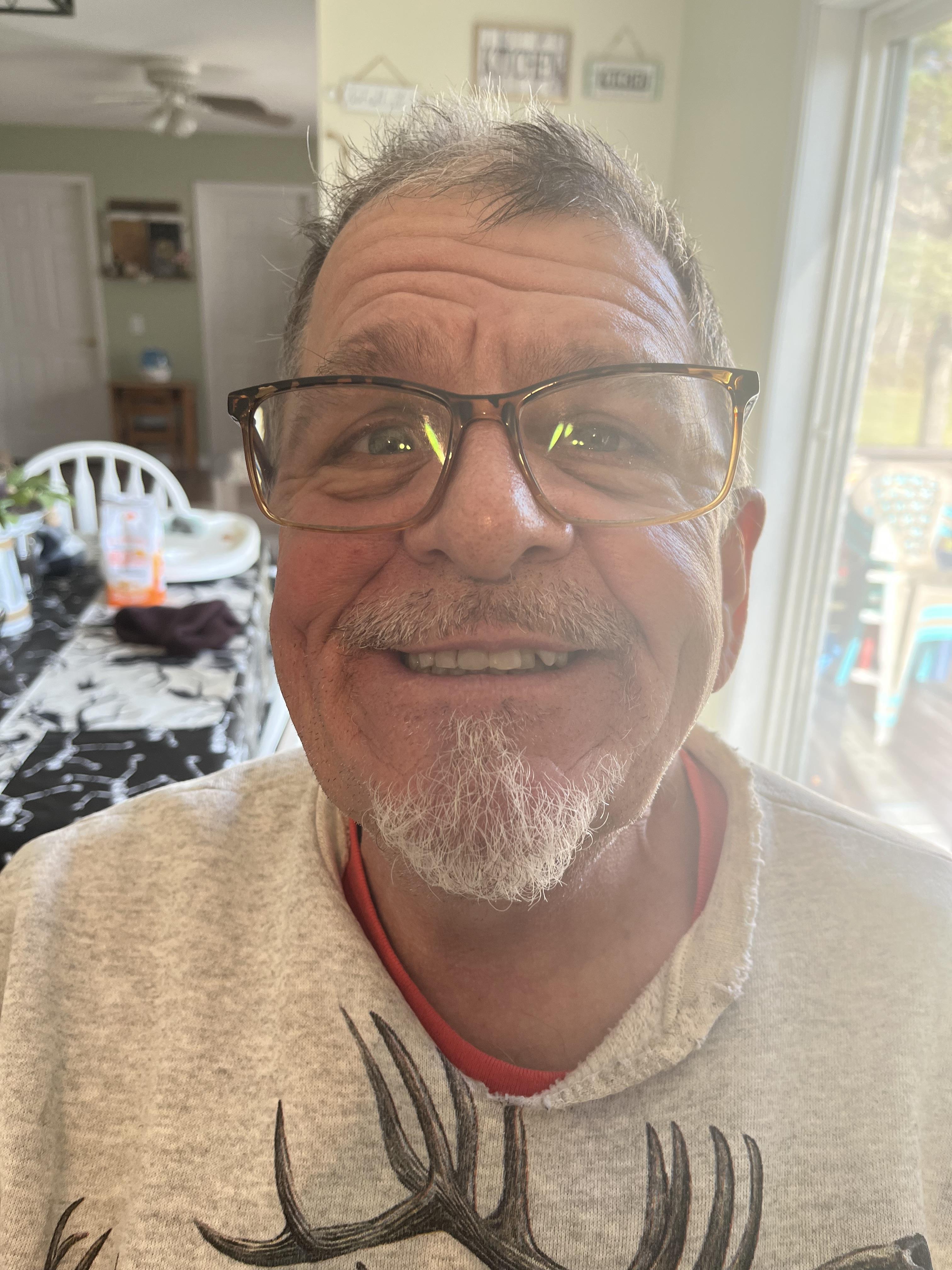 A man wearing glasses and smiling