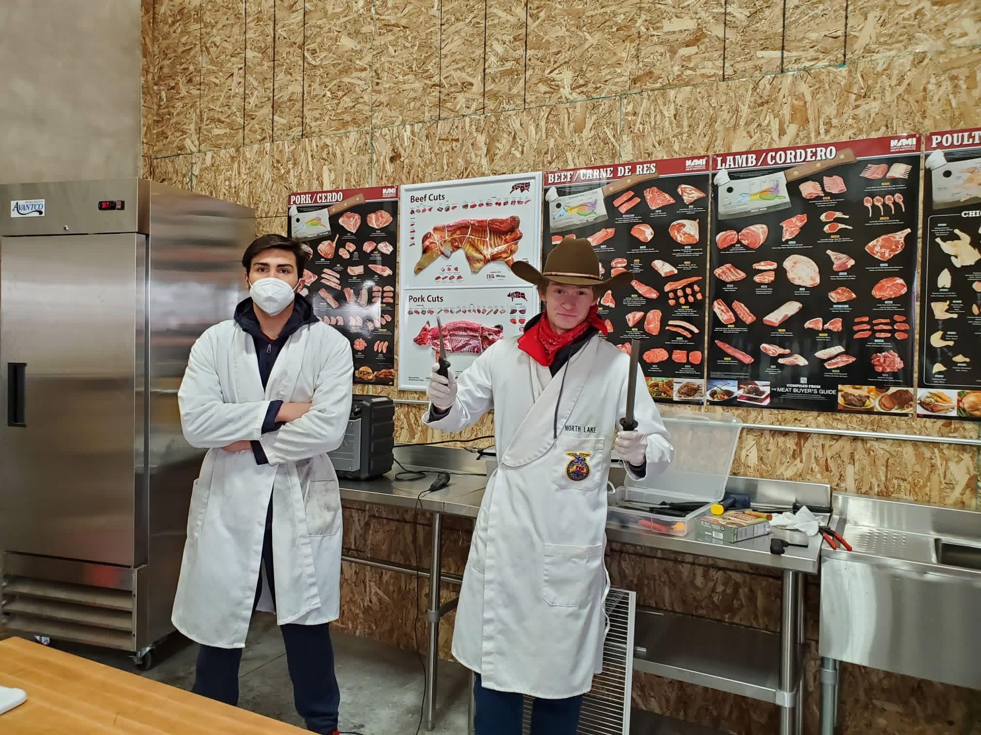 Two men wearing white coats and a cowboy hat
