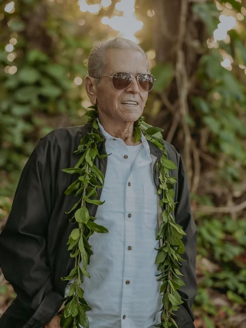 A man wearing sunglasses and a necklace