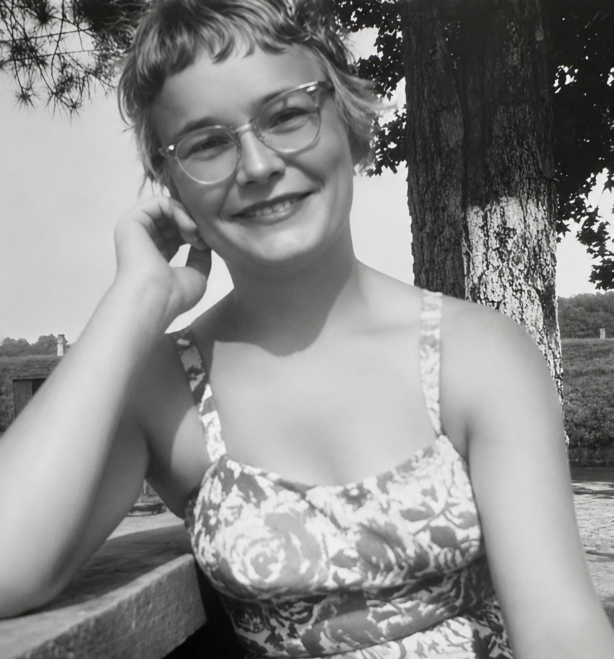 A woman wearing glasses and smiling