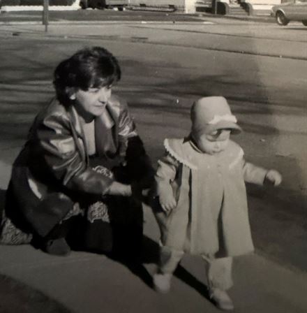 A woman kneeling next to a baby