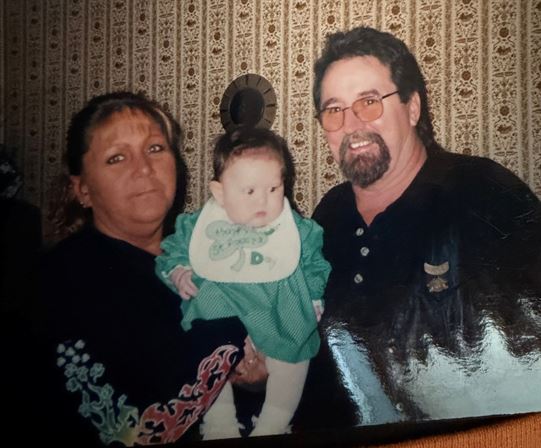 A man and woman holding a baby