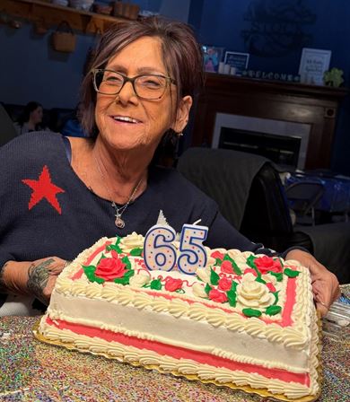A woman sitting at a table with a cake