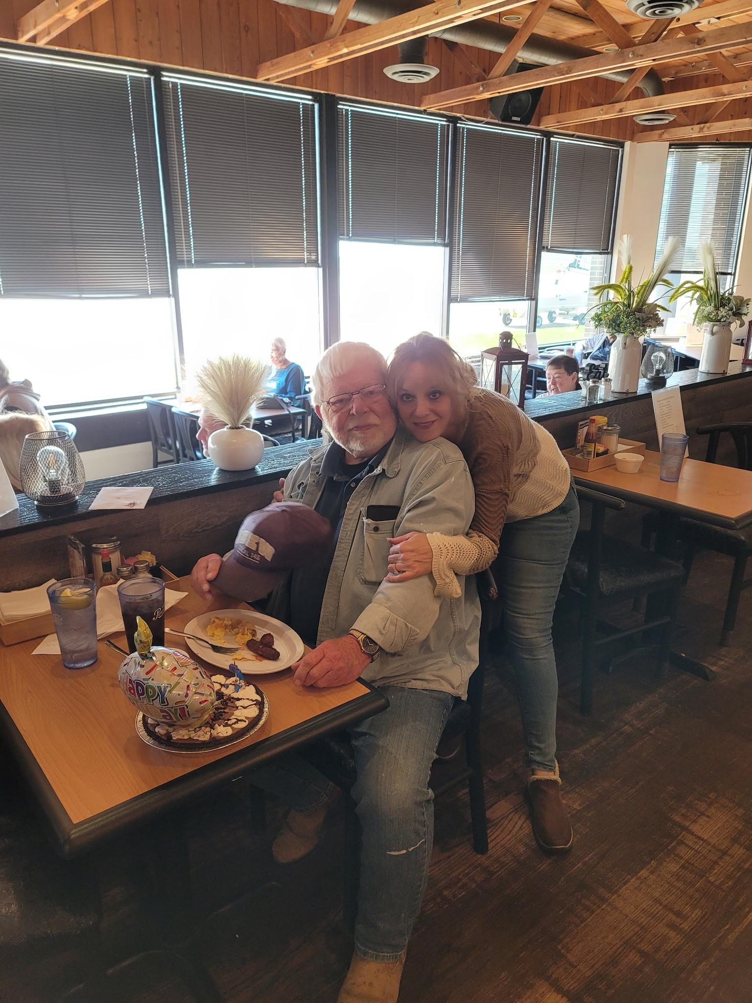A man and woman sitting at a table with food