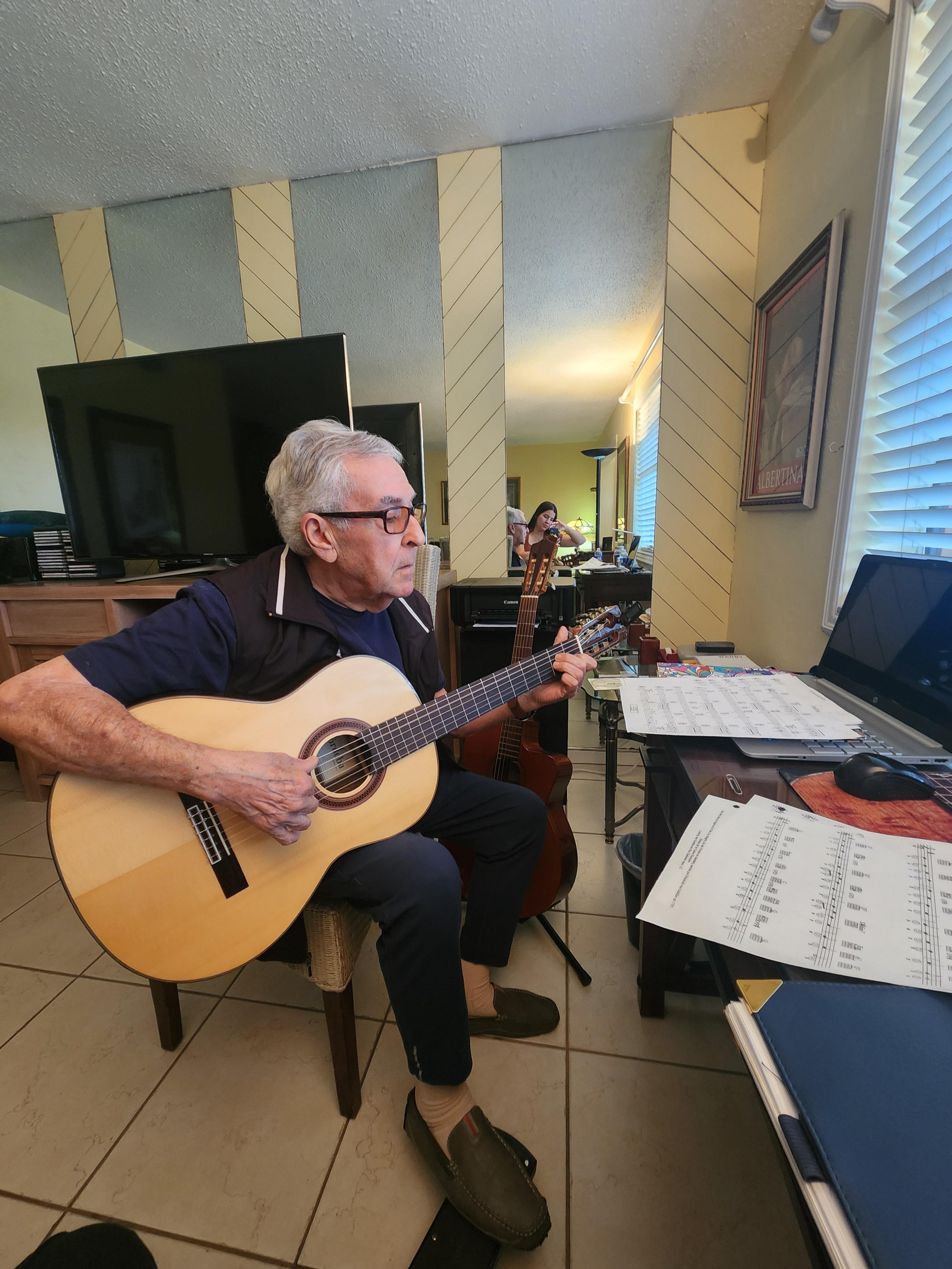 A man sitting in a chair playing a guitar