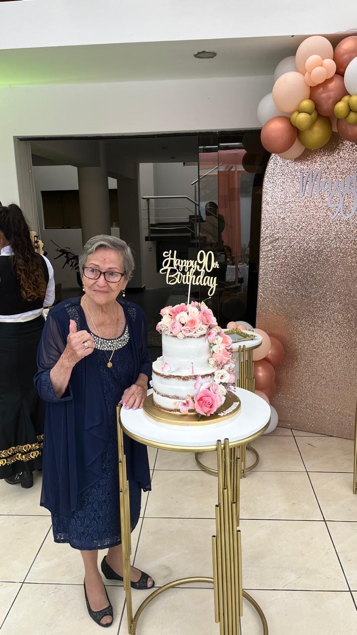 A woman standing next to a cake