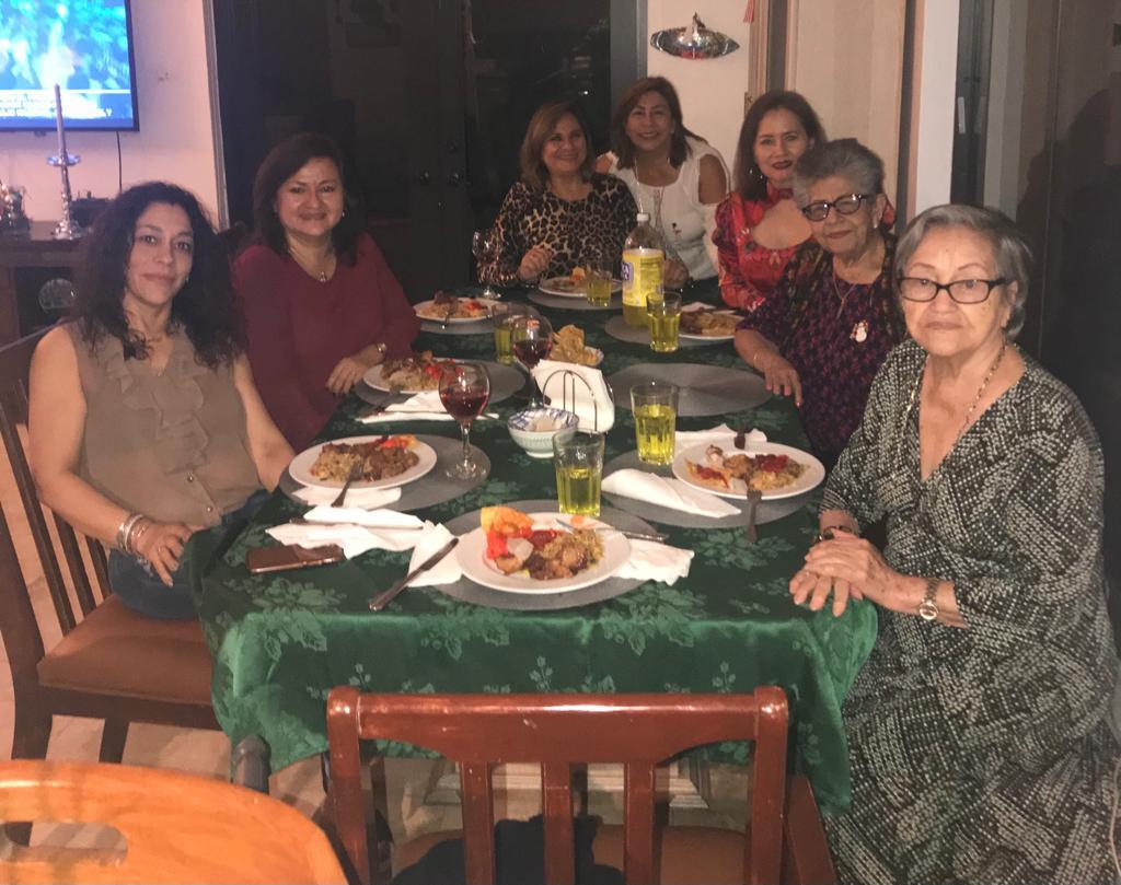 A group of women sitting at a table with plates of food