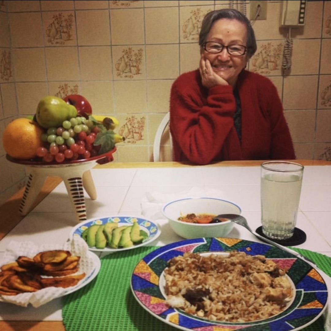 A woman sitting at a table with plates of food