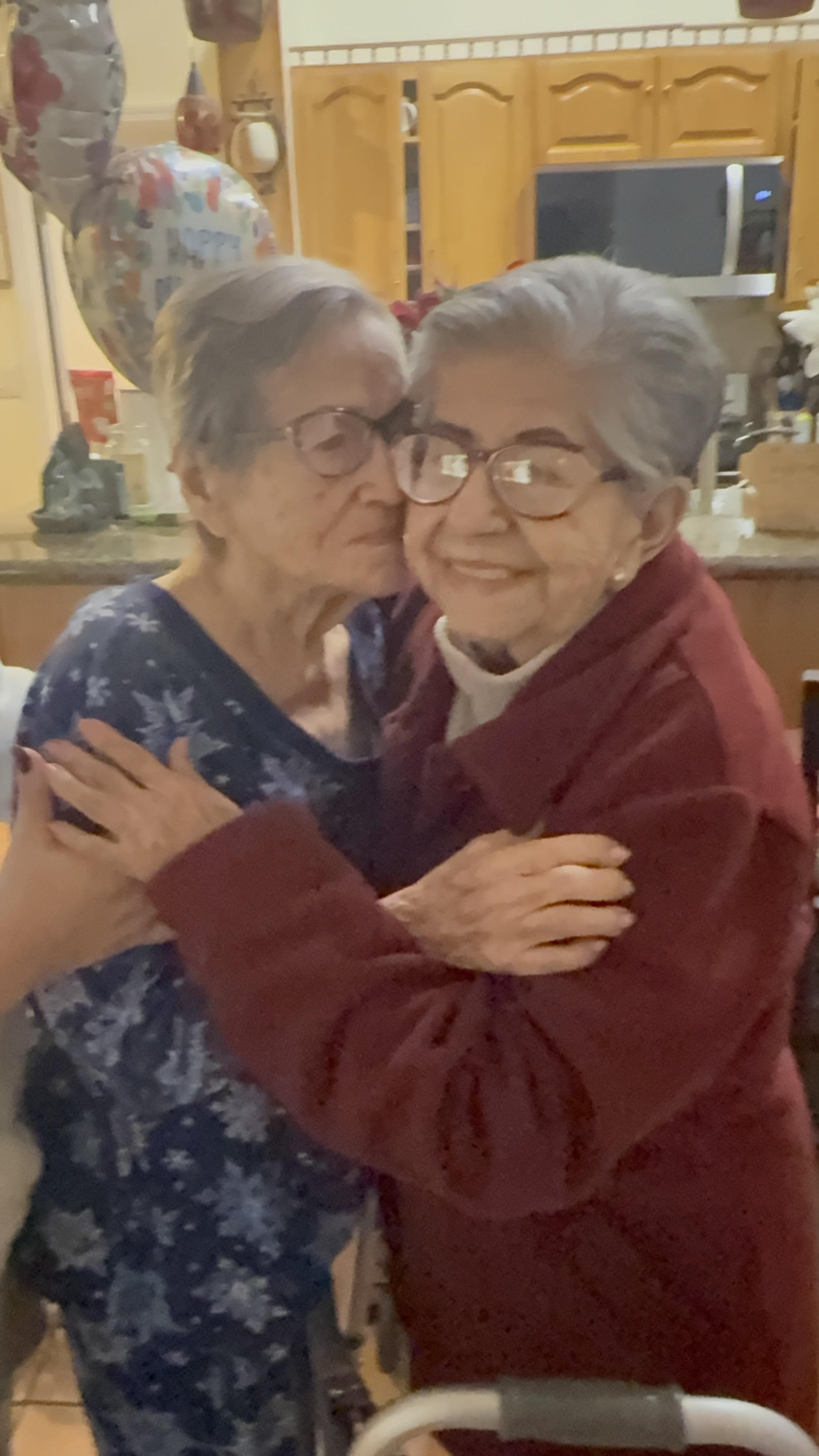 Two women hugging each other