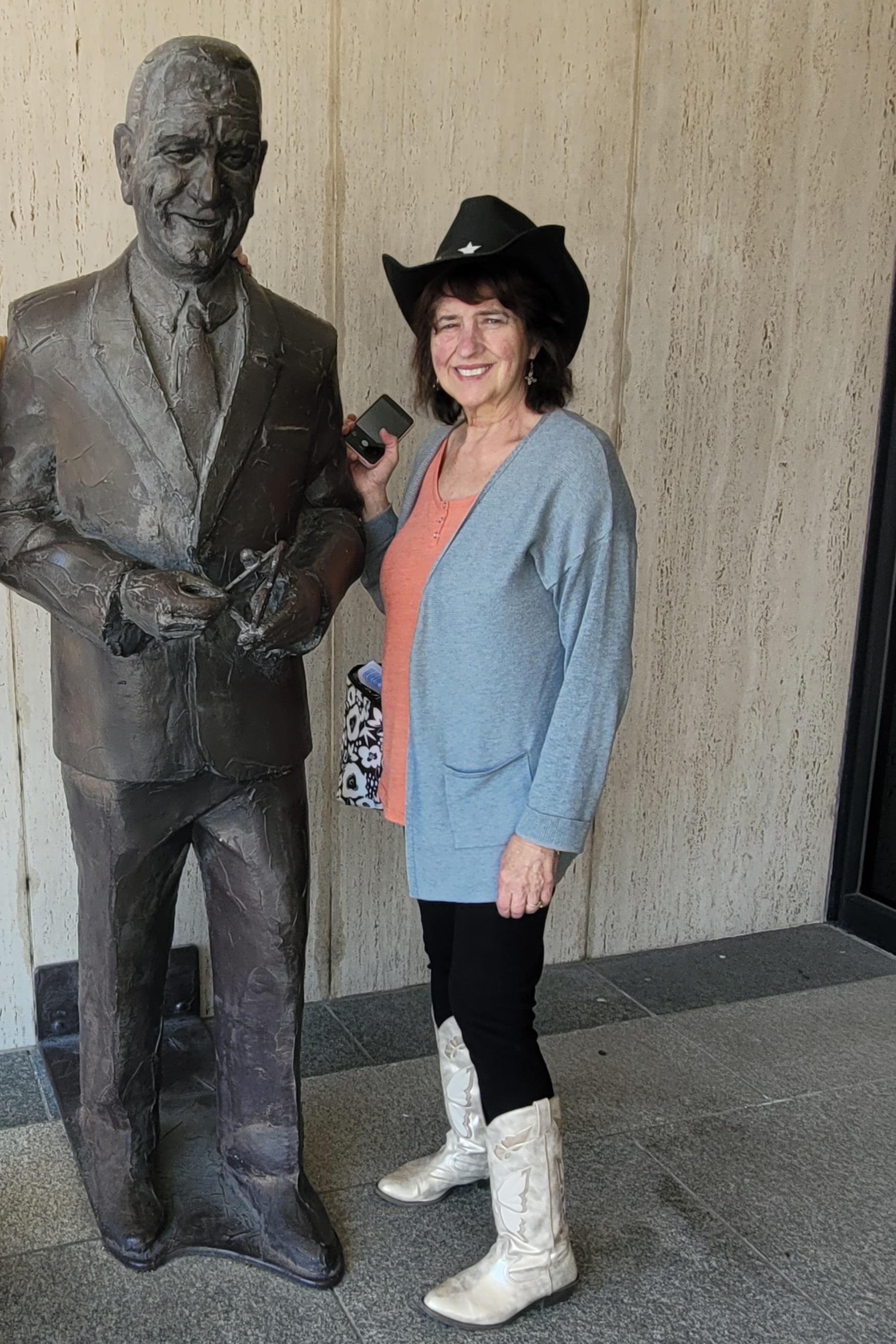 A woman standing next to a statue