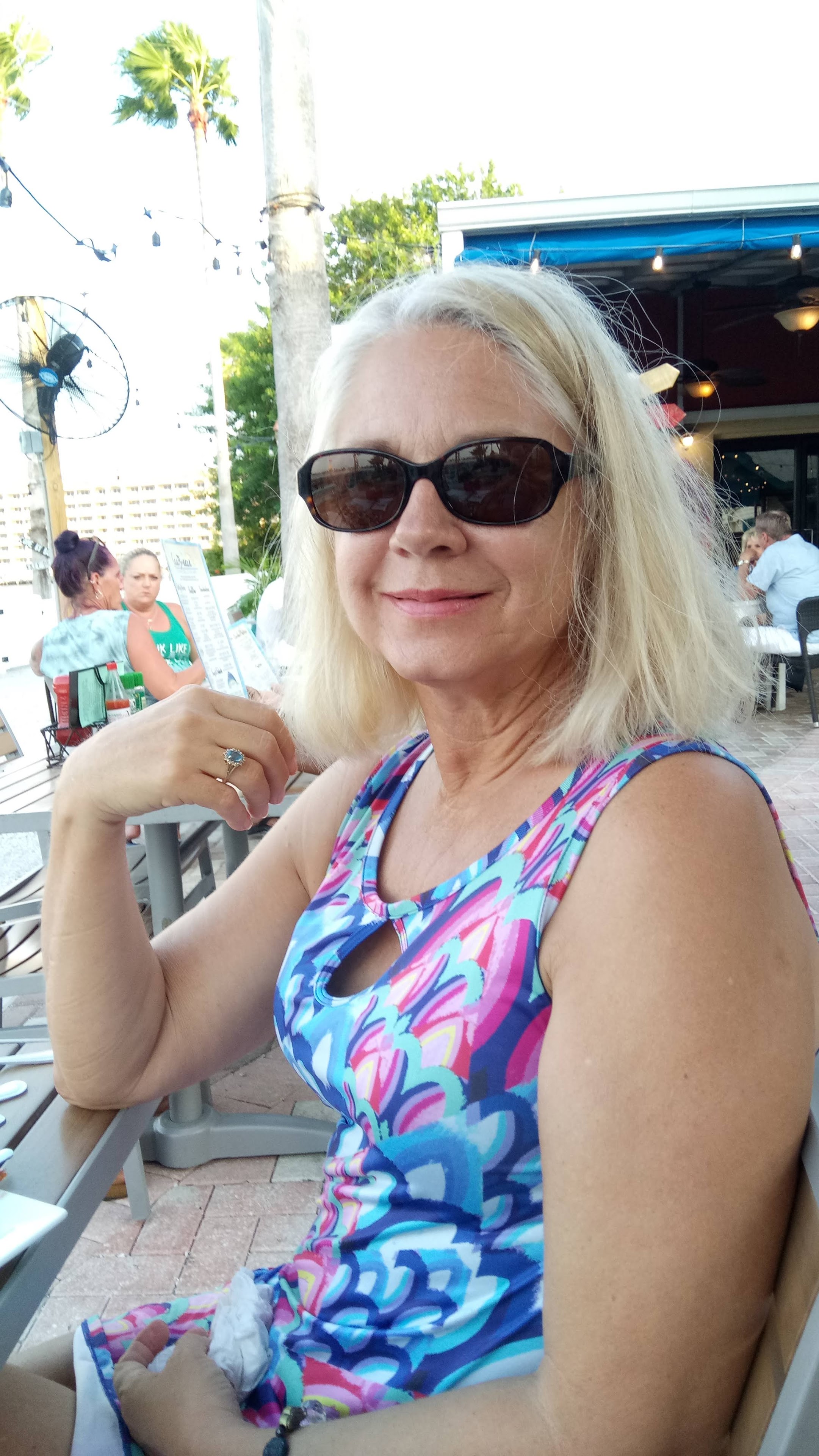 A woman wearing sunglasses sitting at a table