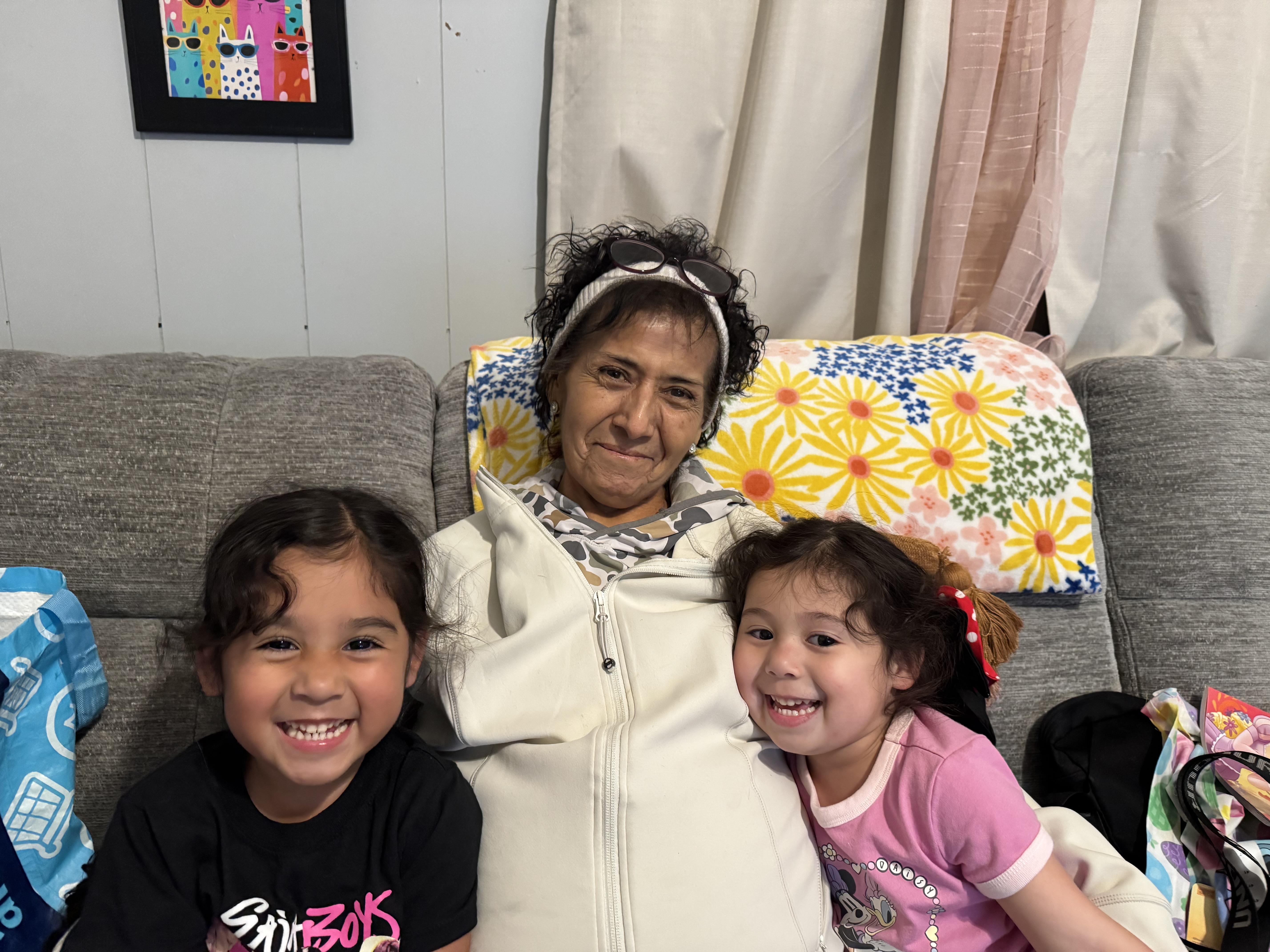 A woman and two children sitting on a couch