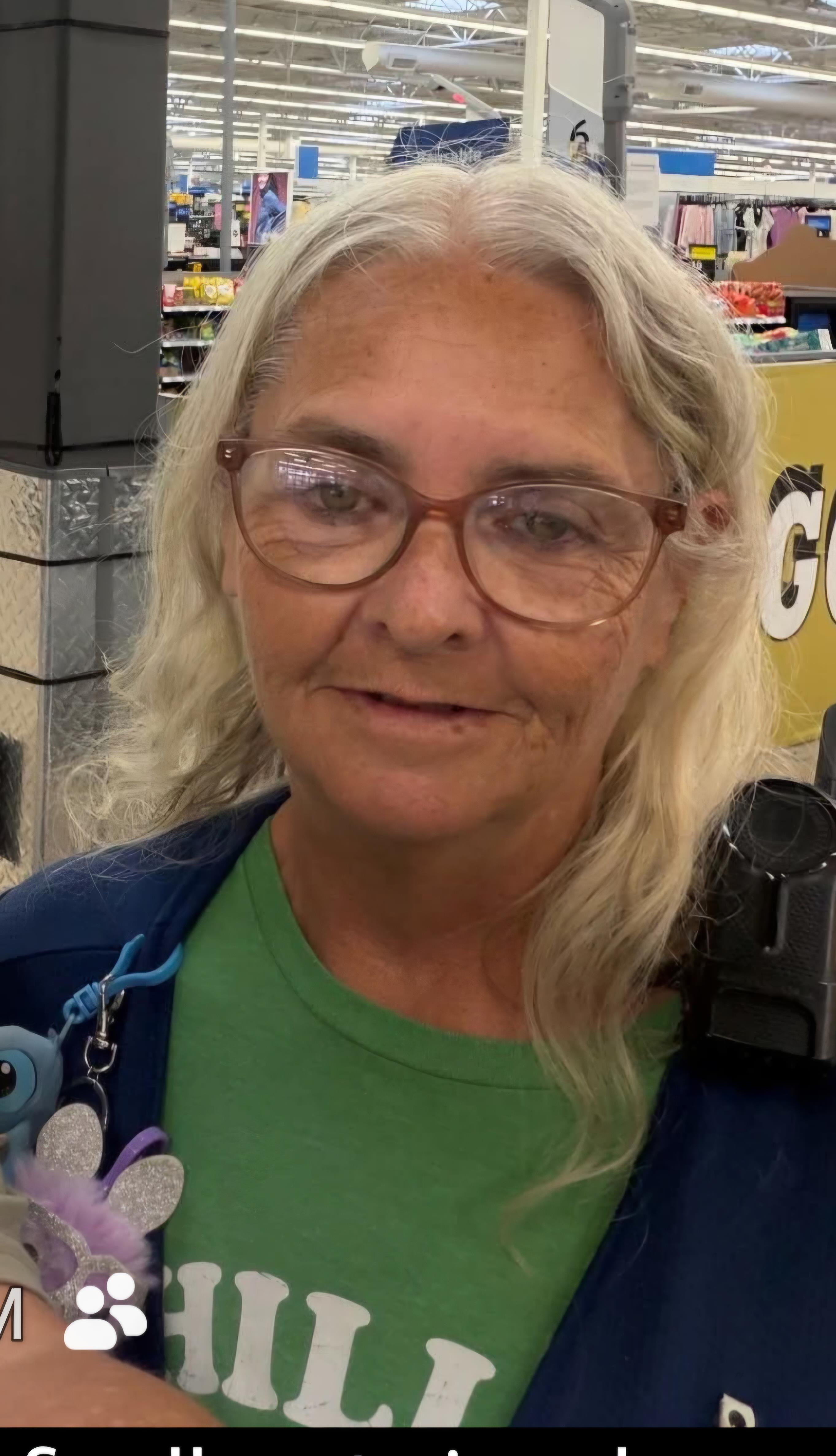 A woman with glasses smiling