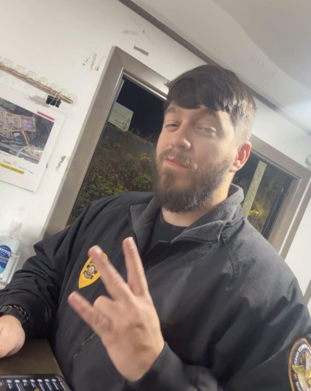 A man with a beard making a hand gesture
