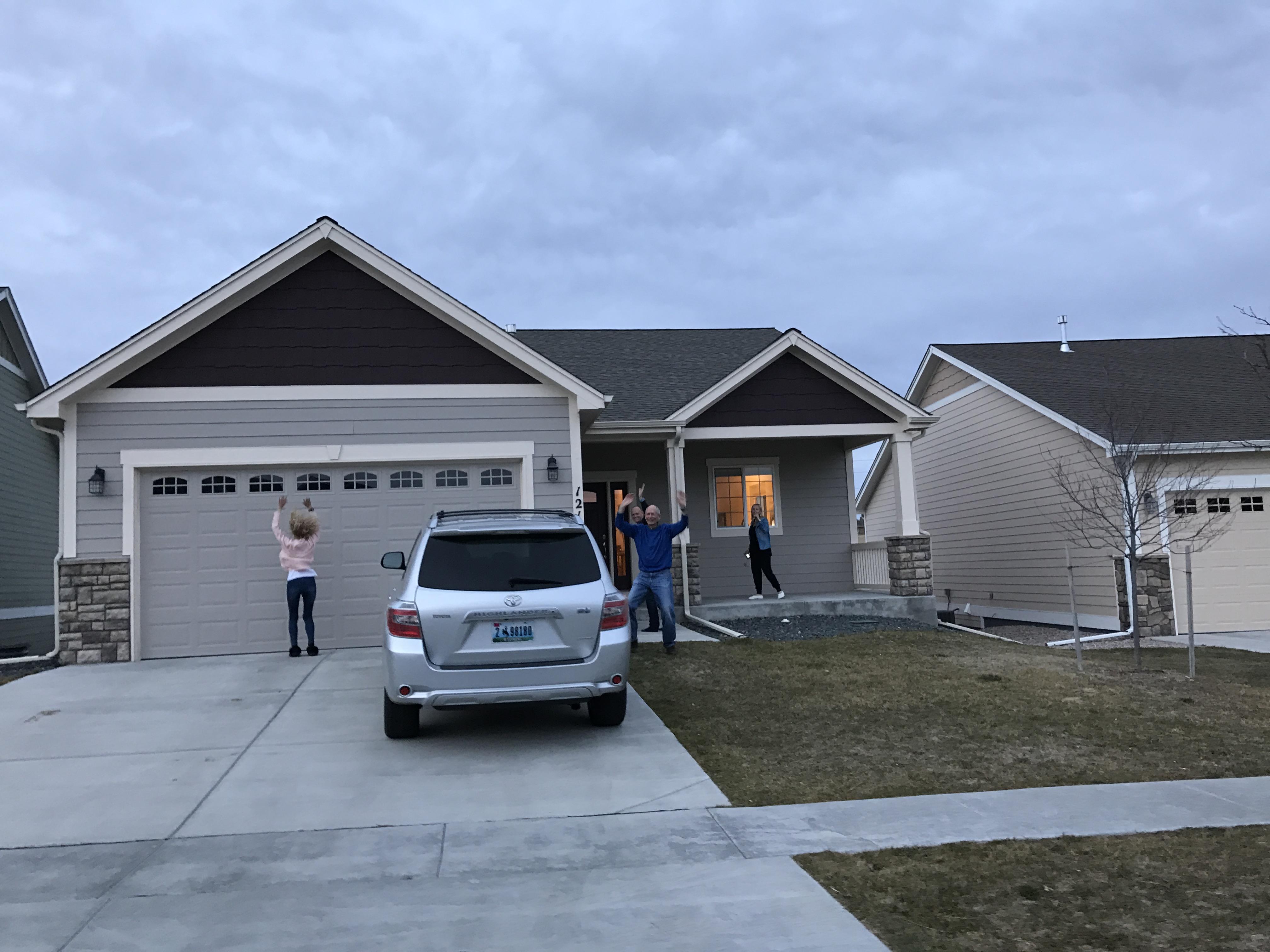 A group of people standing in front of a house