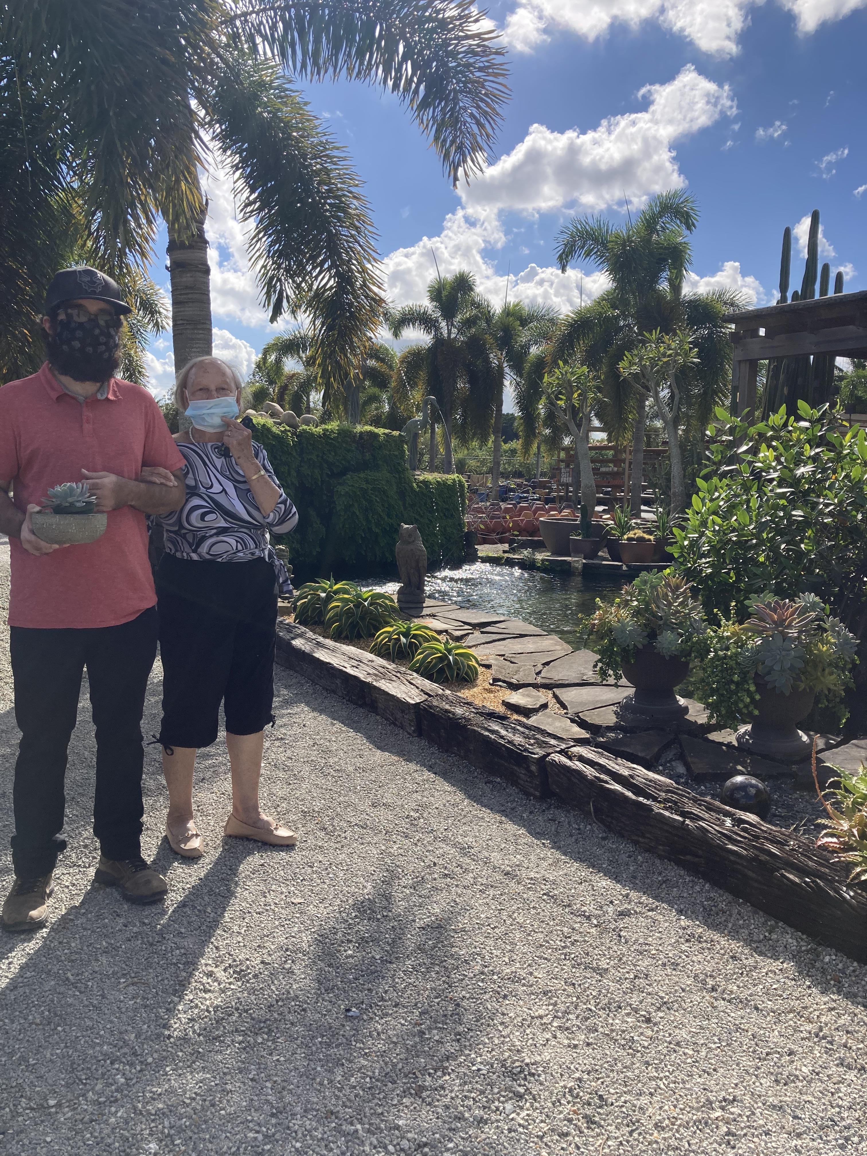 A man and woman standing in front of a garden