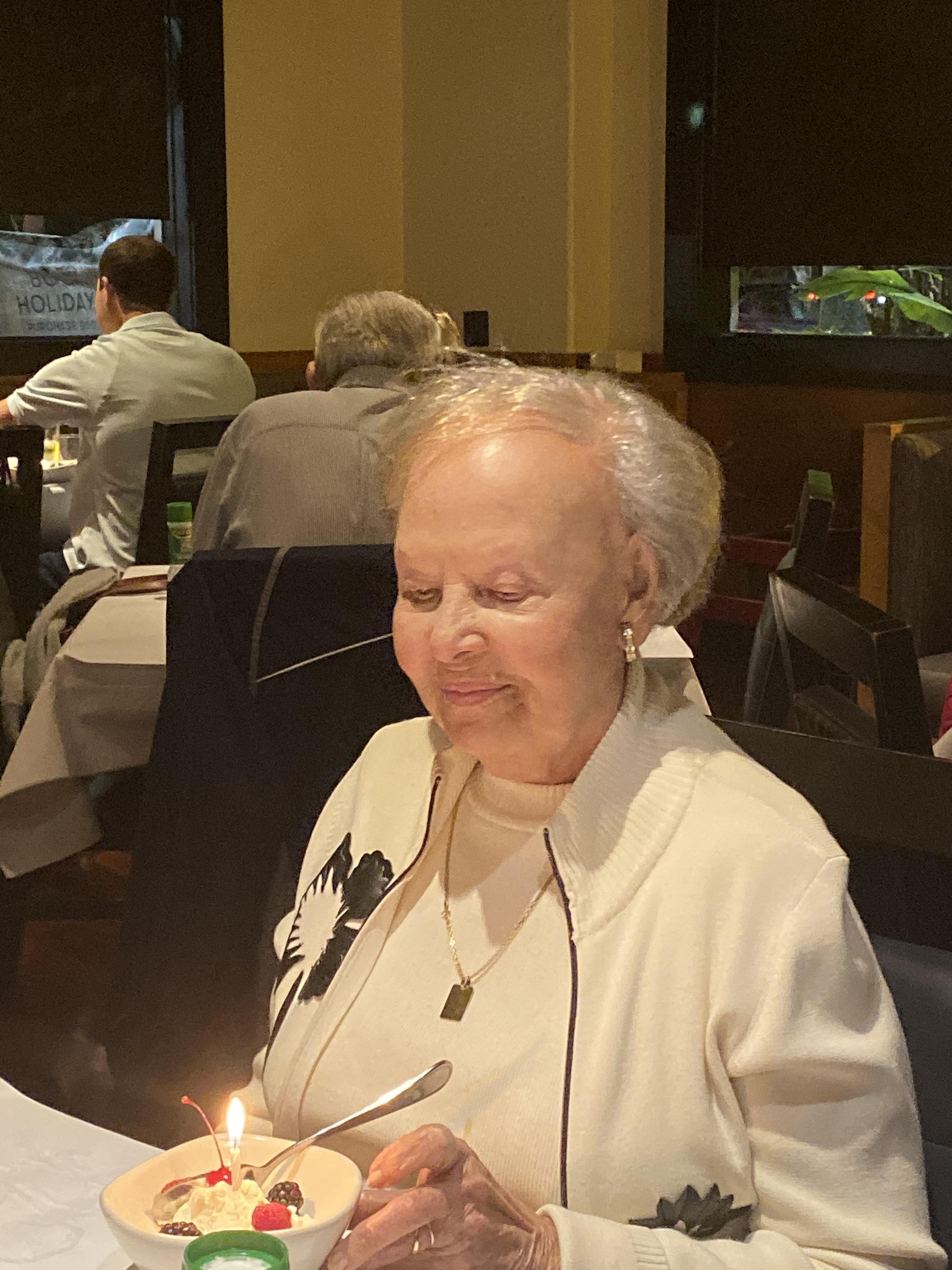 A woman sitting at a table with a lit candle