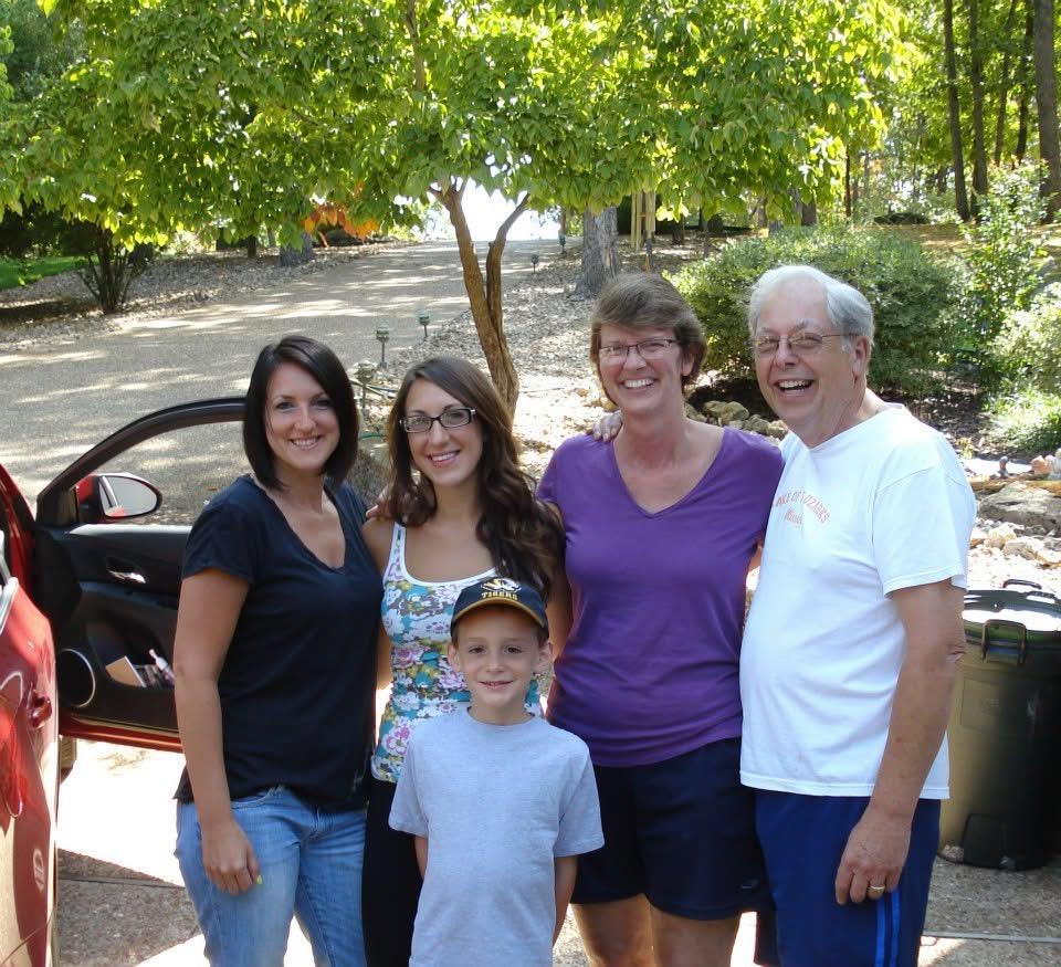 A group of people standing in front of a car
