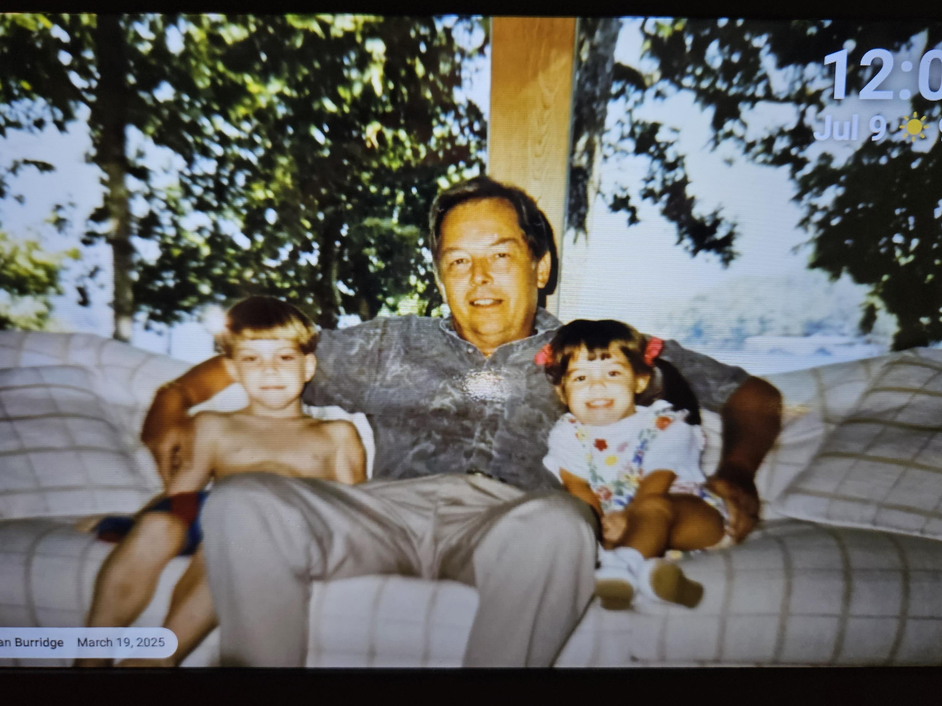 A man sitting on a couch with two children