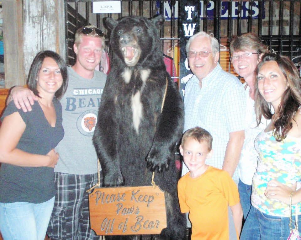 A group of people posing with a bear