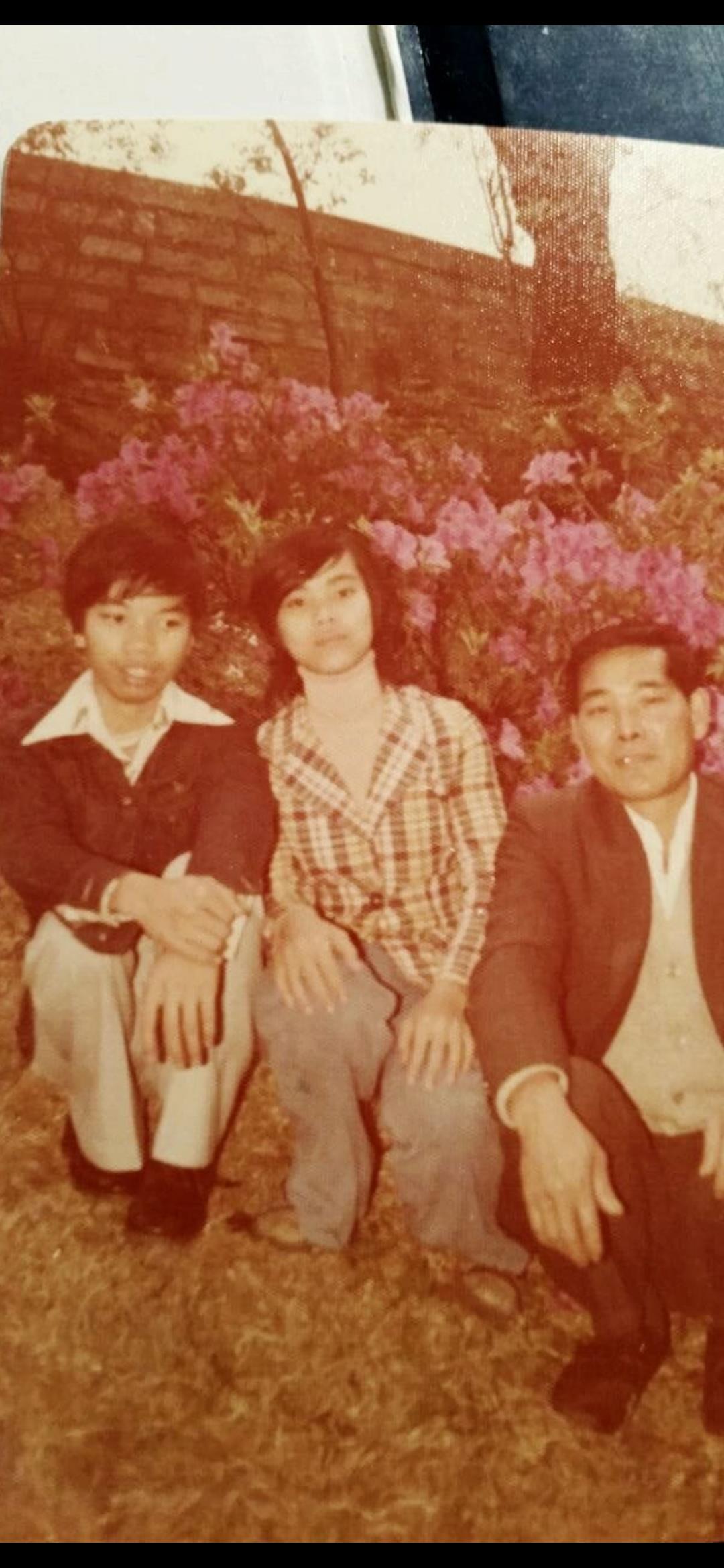 A group of people sitting in front of a bush