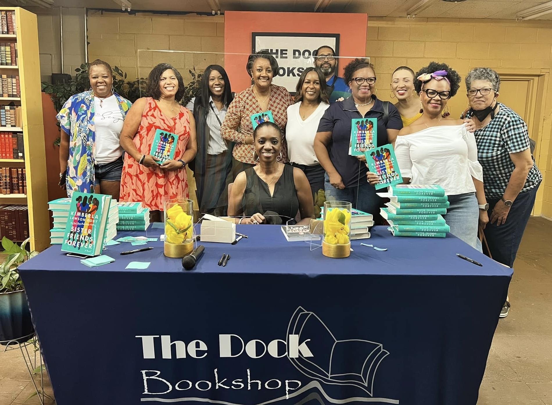 A group of people standing around a table with books